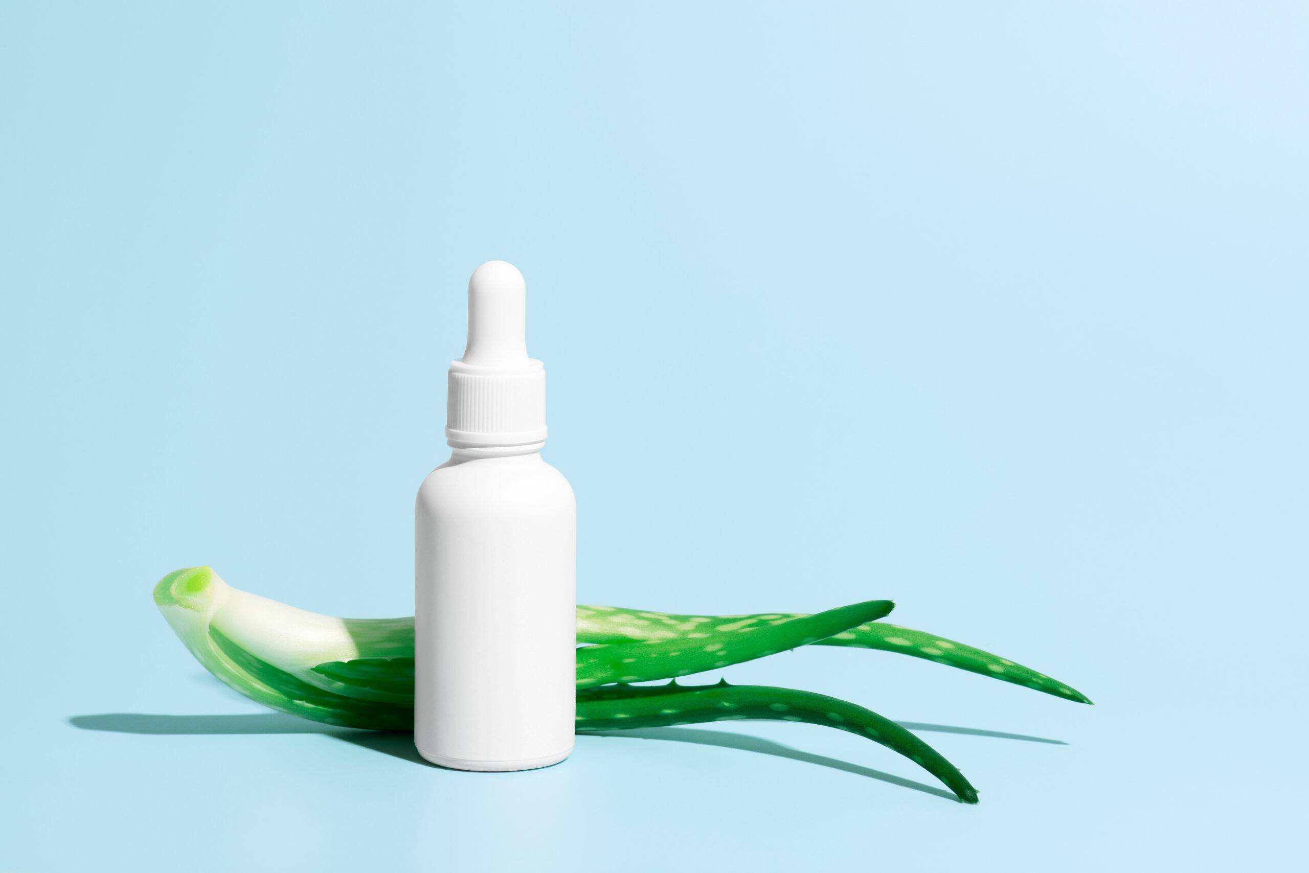 Image showing a dropper bottle of Aloe Vera Serum next to fresh aloe vera leaves, representing FC Materials' commitment to natural personal care products.