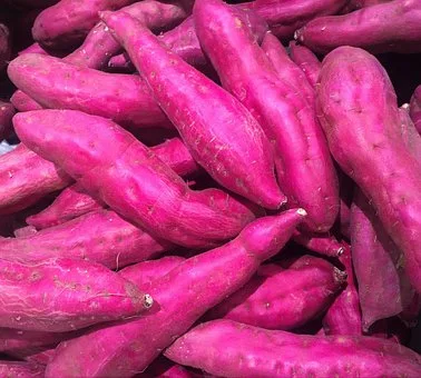 A pile of pink sweet potatoes in a market.