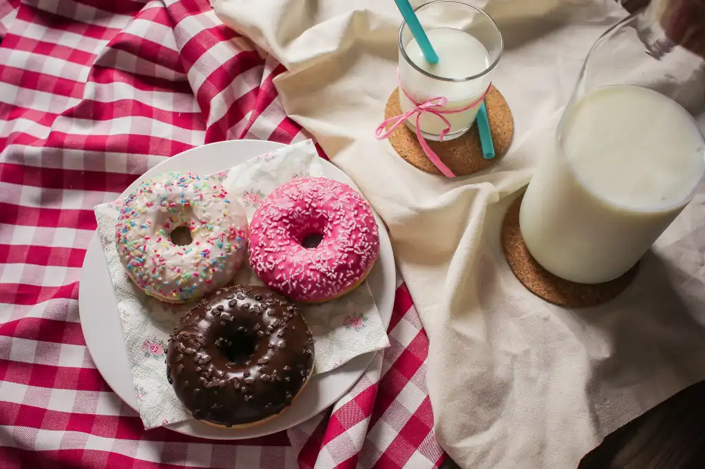 A plate of donuts and a glass of milk.