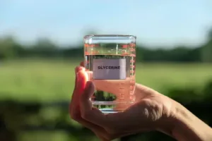 A bottle of glycerine with a backdrop of diverse applications and industries.