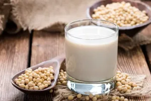 A spoonful of soybeans beside a soybean pod, highlighting the nutrient-packed soybean peptide.
