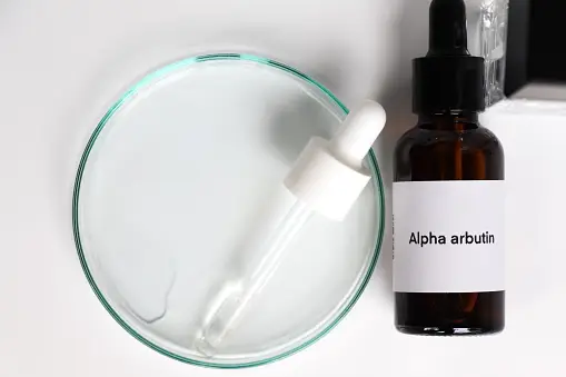 A bottle of skincare serum with the label "Alpha Arbutin"