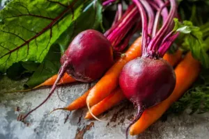Fresh beets and carrots, packed with essential nutrients, beautifully arranged on a table.