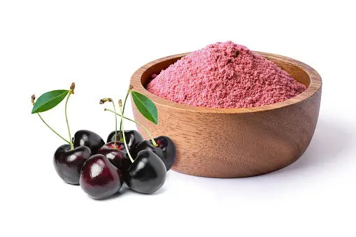 Cherry powder and cherries in a wooden bowl.
