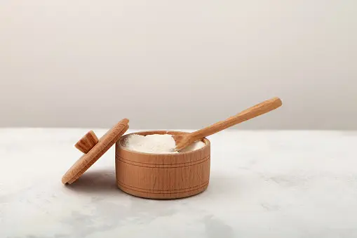 A wooden container with a spoon on top.
