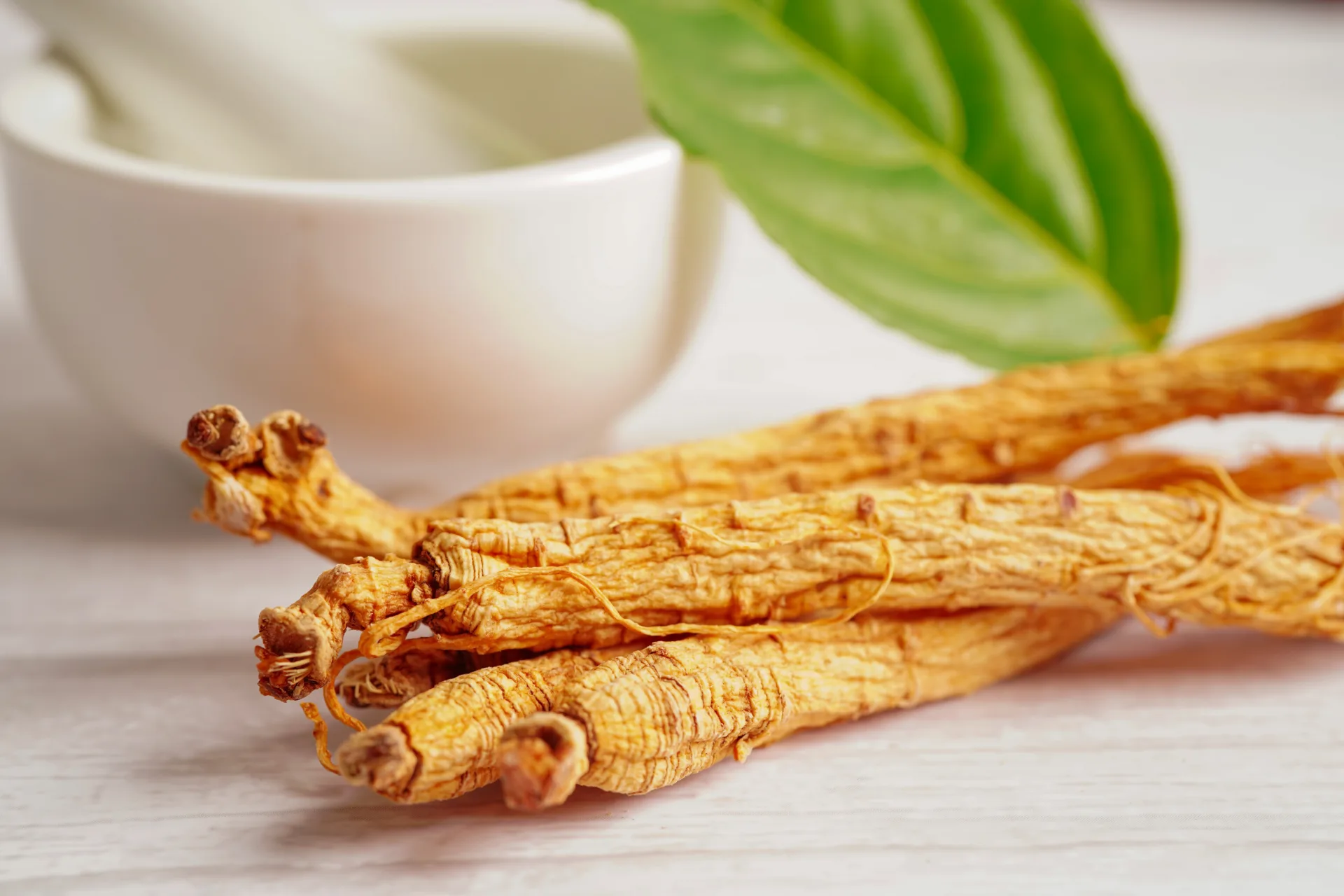Dried ginseng roots with mortar and pestle.