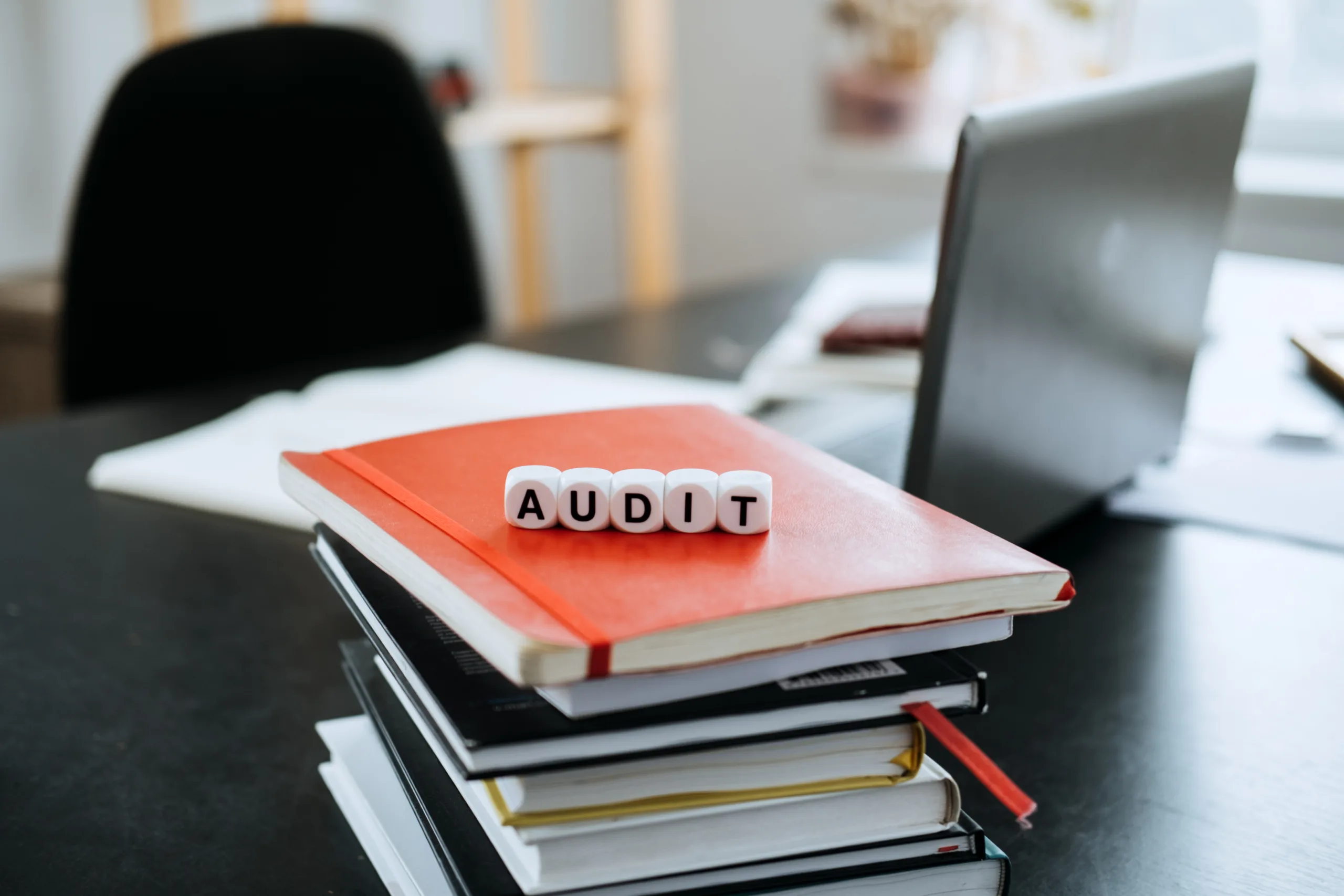 Audit letters on books near laptop