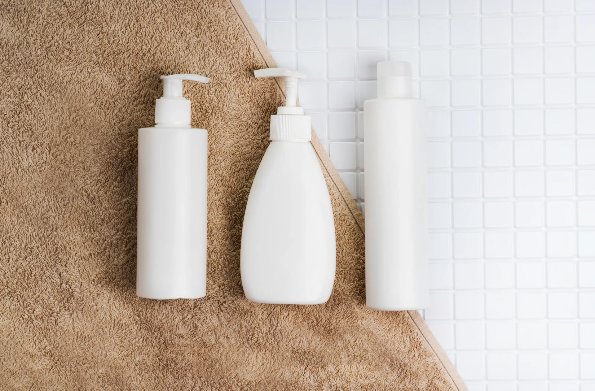 White bottles on brown towel background