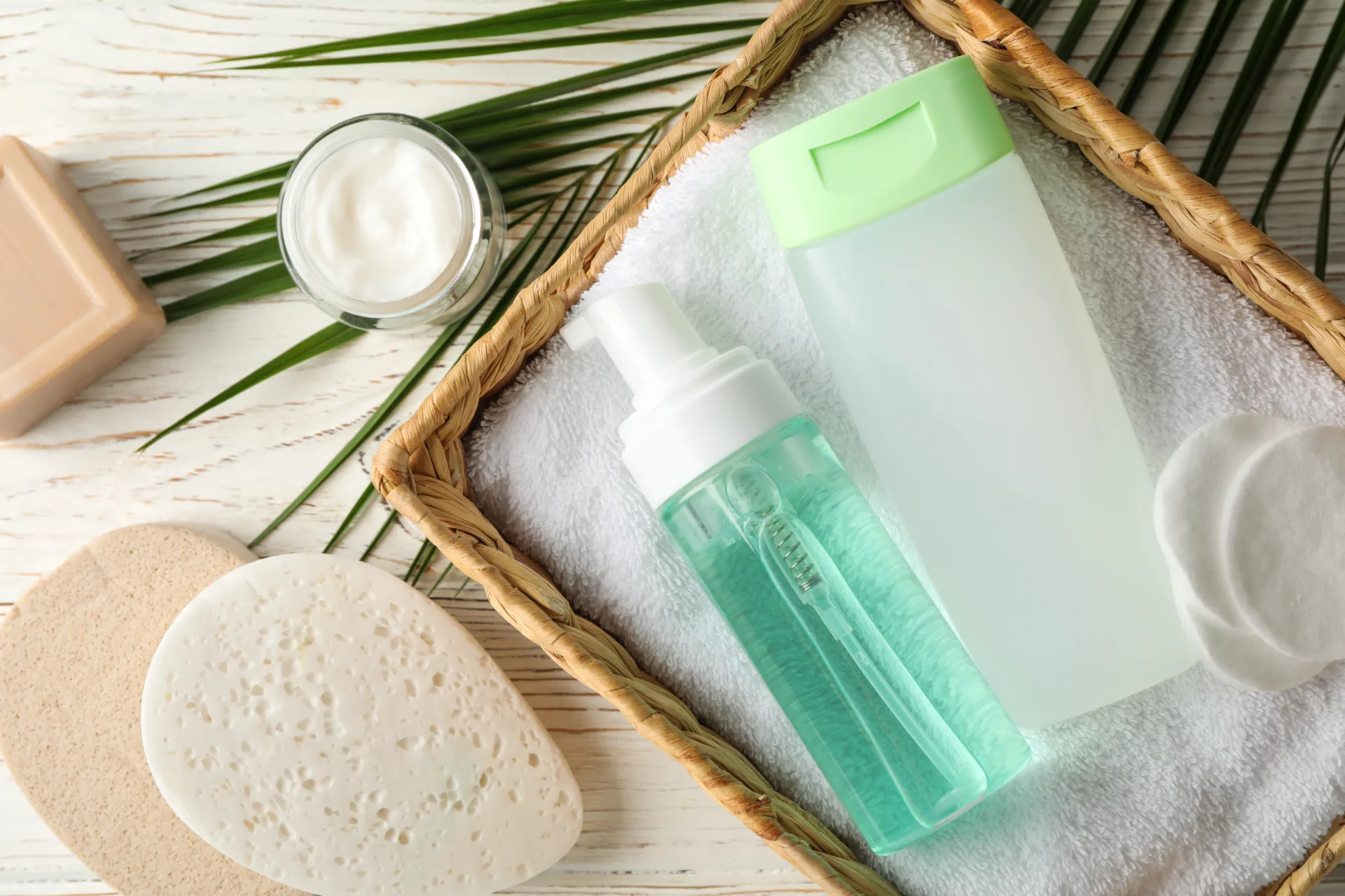Skincare products in basket on white towel