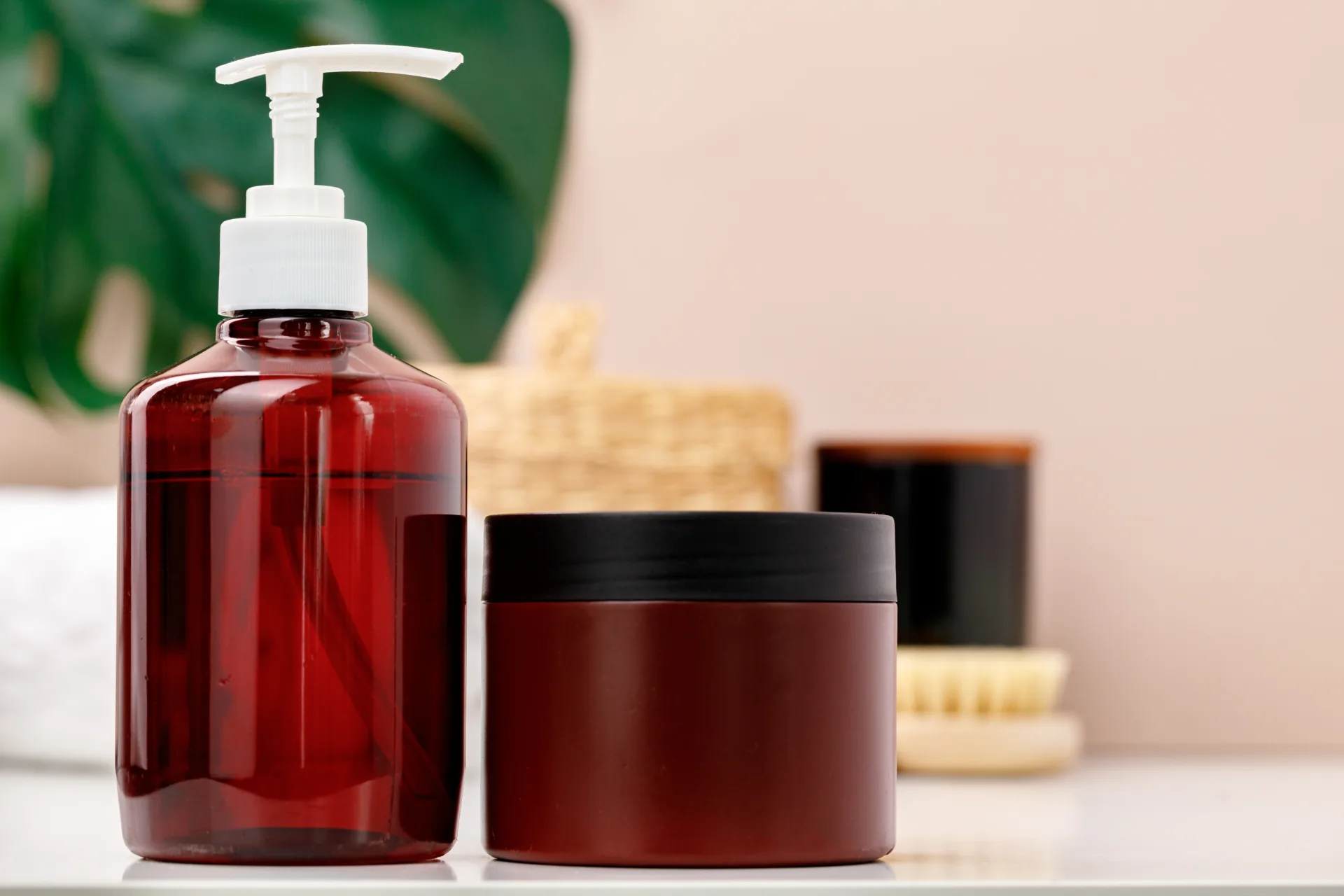 Red pump bottle and jar on bathroom counter.