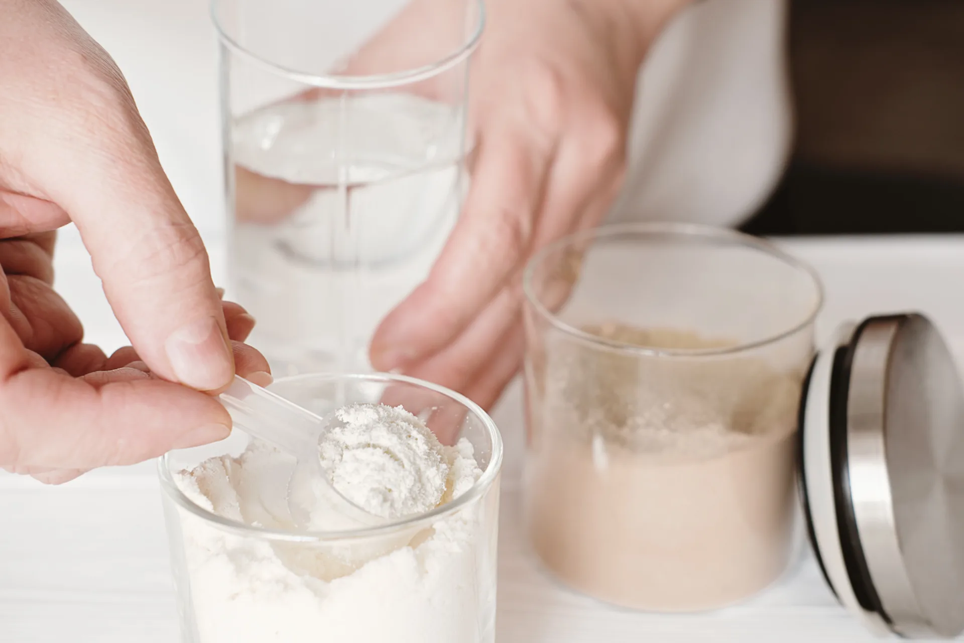 Scooping powder into a glass of water
