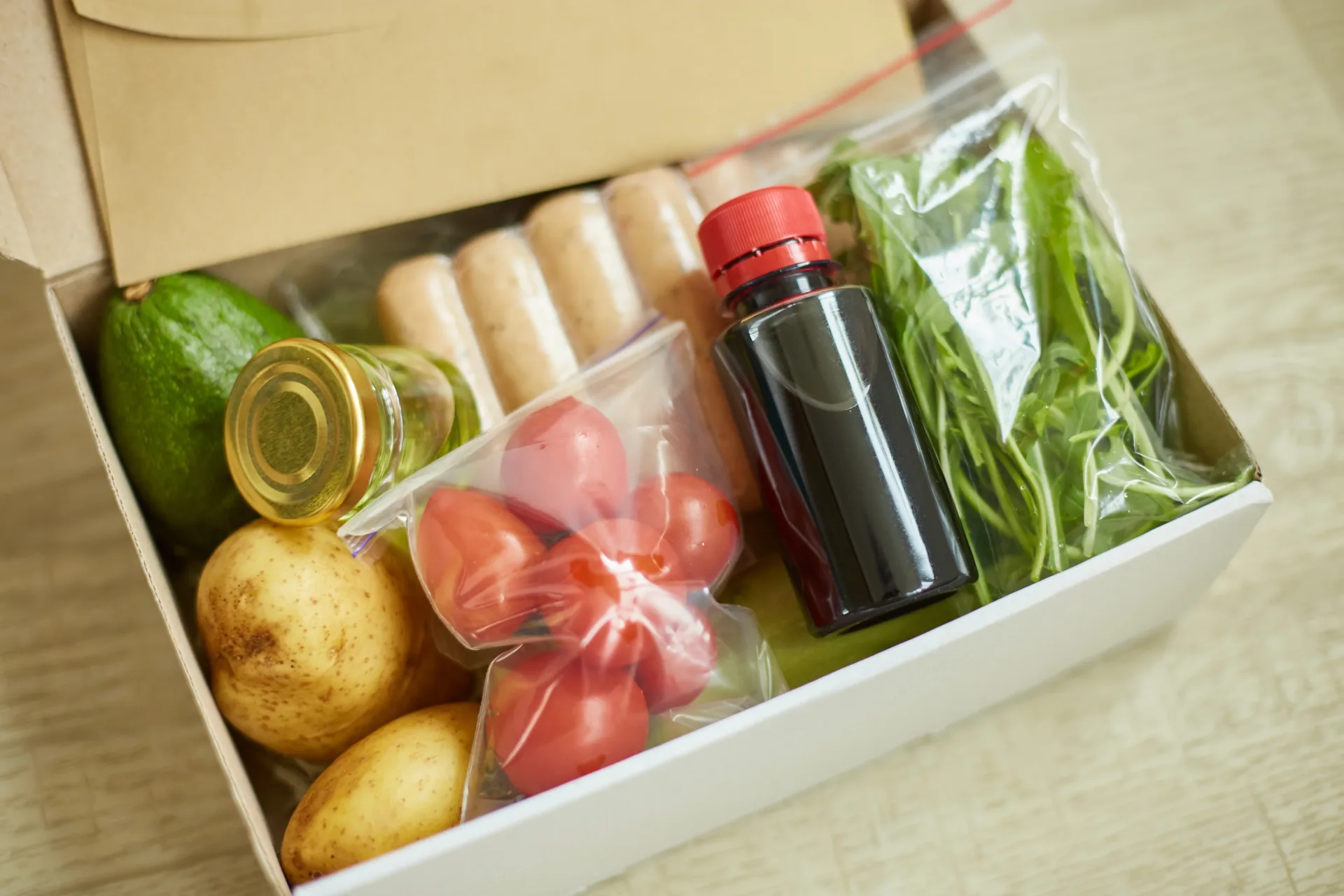 Grocery box with fresh vegetables and ingredients.