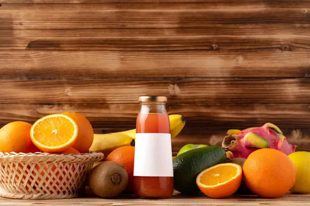 Fresh juices with assorted fruits on wooden background.