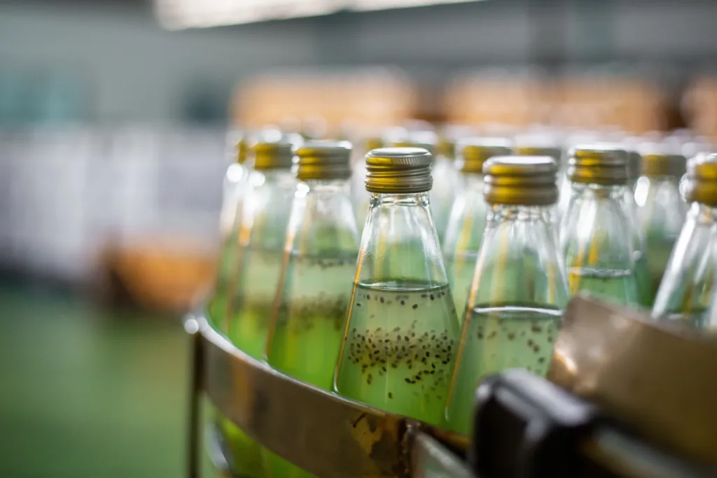 Bottles of green juice on conveyor belt.