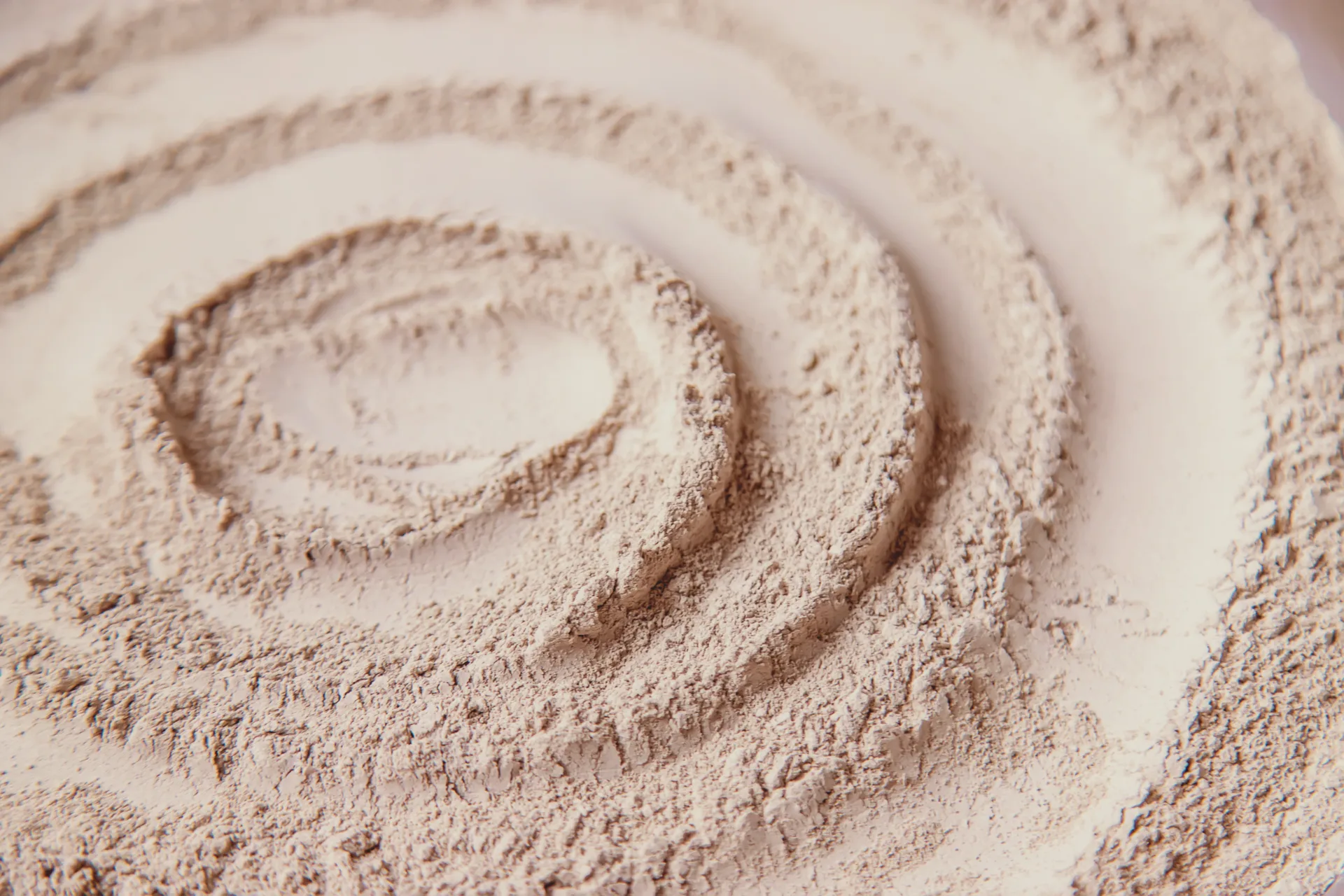 Swirling pattern in fine beige powder texture.