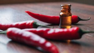Red chili peppers and capsicum oil extract bottle, editorial food photography