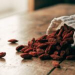 Dried goji berries on a rustic wooden table, editorial food photography