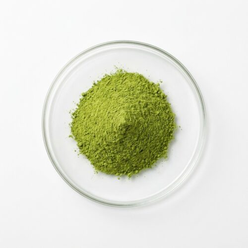 Green green tea extract powder in a glass petri dish