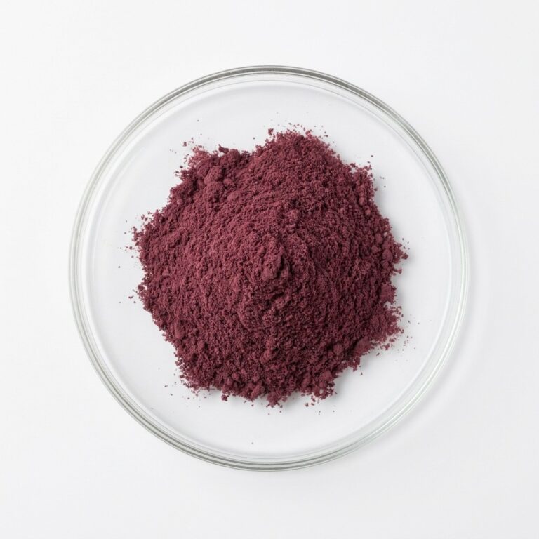 Dark plum fruit powder in a glass petri dish