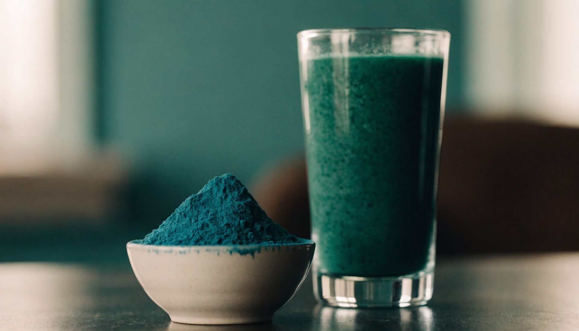 Vivid spirulina powder with green smoothie, editorial food photography