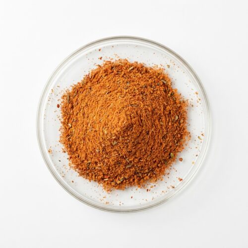 tom-yam-seasoning-powder Reddish-orange tom yam seasoning spice powder blend in a glass petri dish
