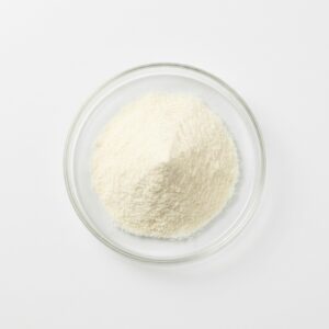 Fine cream-white whole milk powder in a glass petri dish