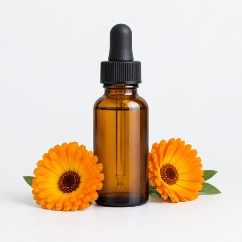 Calendula Oil Calendula oil in an amber dropper bottle beside two fresh calendula flowers